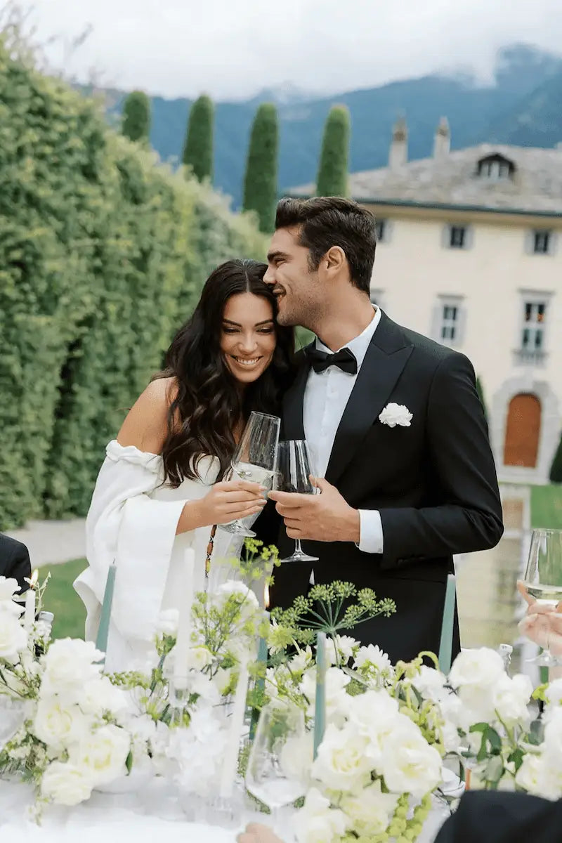 Wedding at Villa Balbiano Champagne Toast Grrom and Bride holding wine glasses and kissing