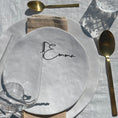 Load image into Gallery viewer, A beautifully set table featuring a white plate with a customizable name tag saying "Emma" from the Champagne Collection from Cheers Day. The setup includes a gold spoon, a beige napkin, and a wine glass with a "Cheers" drink topper. The glass charm elegantly marks the wine glass, showcasing the sophisticated and personalized touch of the place card in the tablescape.
