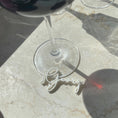 Load image into Gallery viewer, Close-up view of a customizable wine glass marker with the name "Georg" from the Champagne Collection by Cheers Day. The elegant place card alternative is shown attached to the base of a wine glass, highlighting its sophisticated and functional design.
